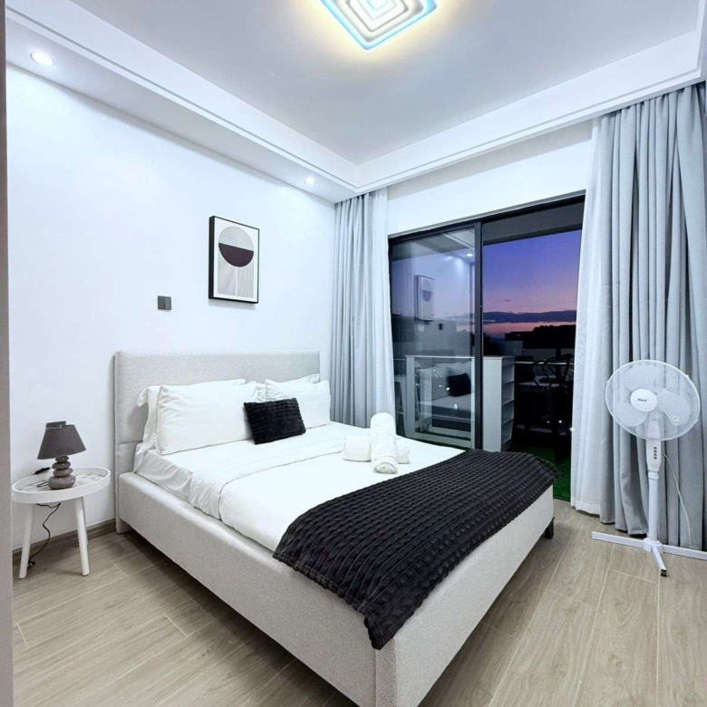 Furnished bedroom with balcony access at Oak Classic Residency in Kilimani