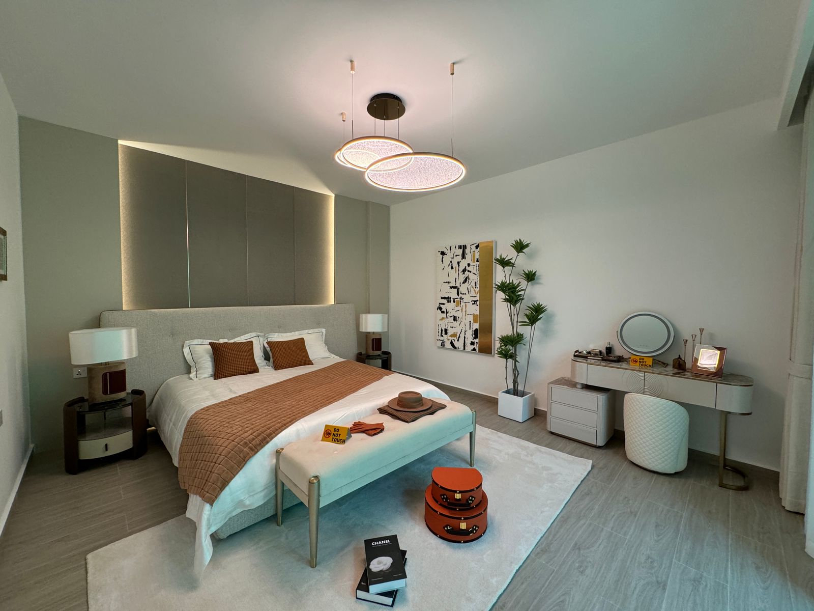 Royal Legend Residence spacious master bedroom featuring an upholstered double bed, modern dressing table, bedside lamps, decorative chandelier, and elegant furnishings.