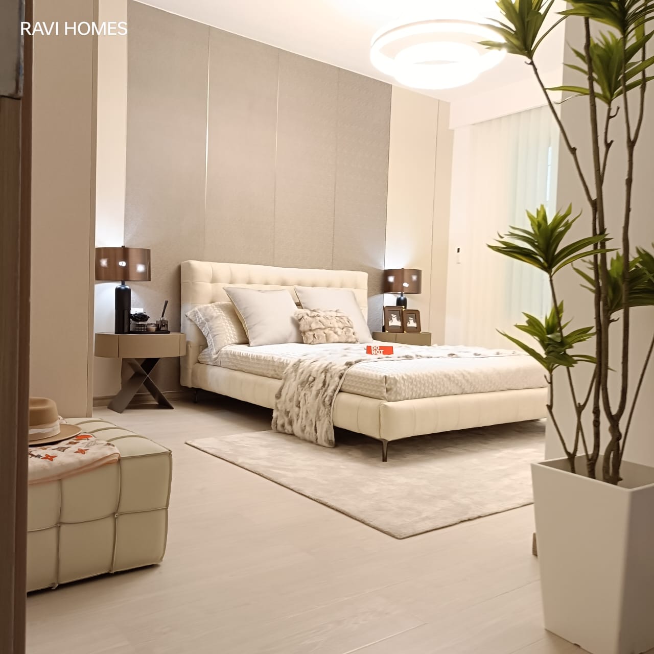 Royal Legend Residence contemporary guest bedroom featuring a cream upholstered bed, bedside tables, soft lighting, decorative wall panels, and elegant neutral furnishings.