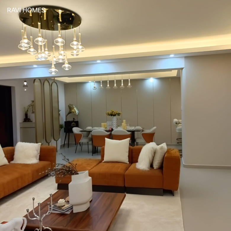 Royal Legend Residence contemporary living and dining room featuring orange sofas, wooden coffee table, decorative pendant lighting, and dining furniture.