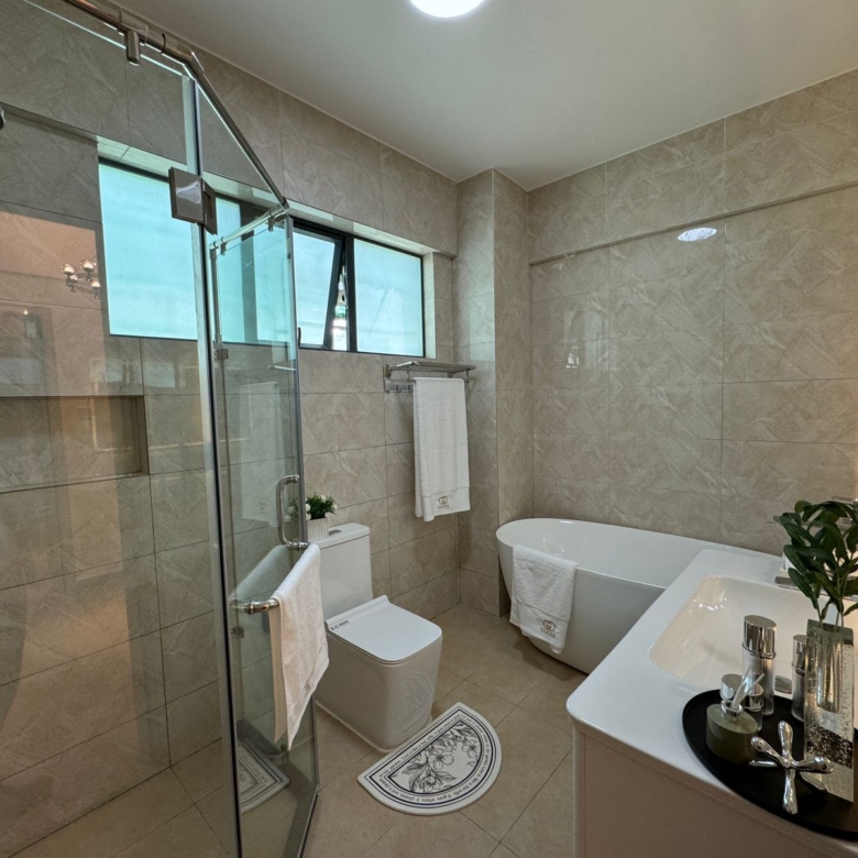 Royal Legend Residence bathroom featuring a glass-enclosed rainfall shower, freestanding bathtub, white vanity, modern toilet, and marble-look tiles.