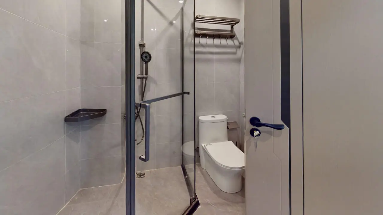 Modern bathroom with glass shower enclosure at Plumeria Residency