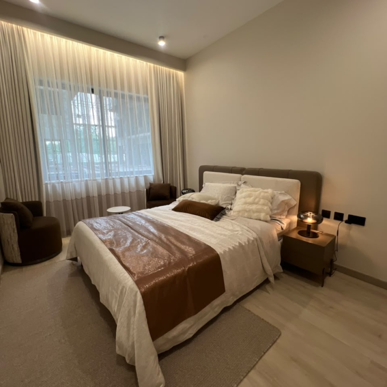 Naturally lit bedroom at Verona Apartments Westlands with an upholstered bed and large window