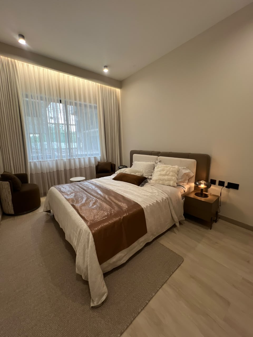 Naturally lit bedroom at Verona Apartments Westlands with an upholstered bed and large window