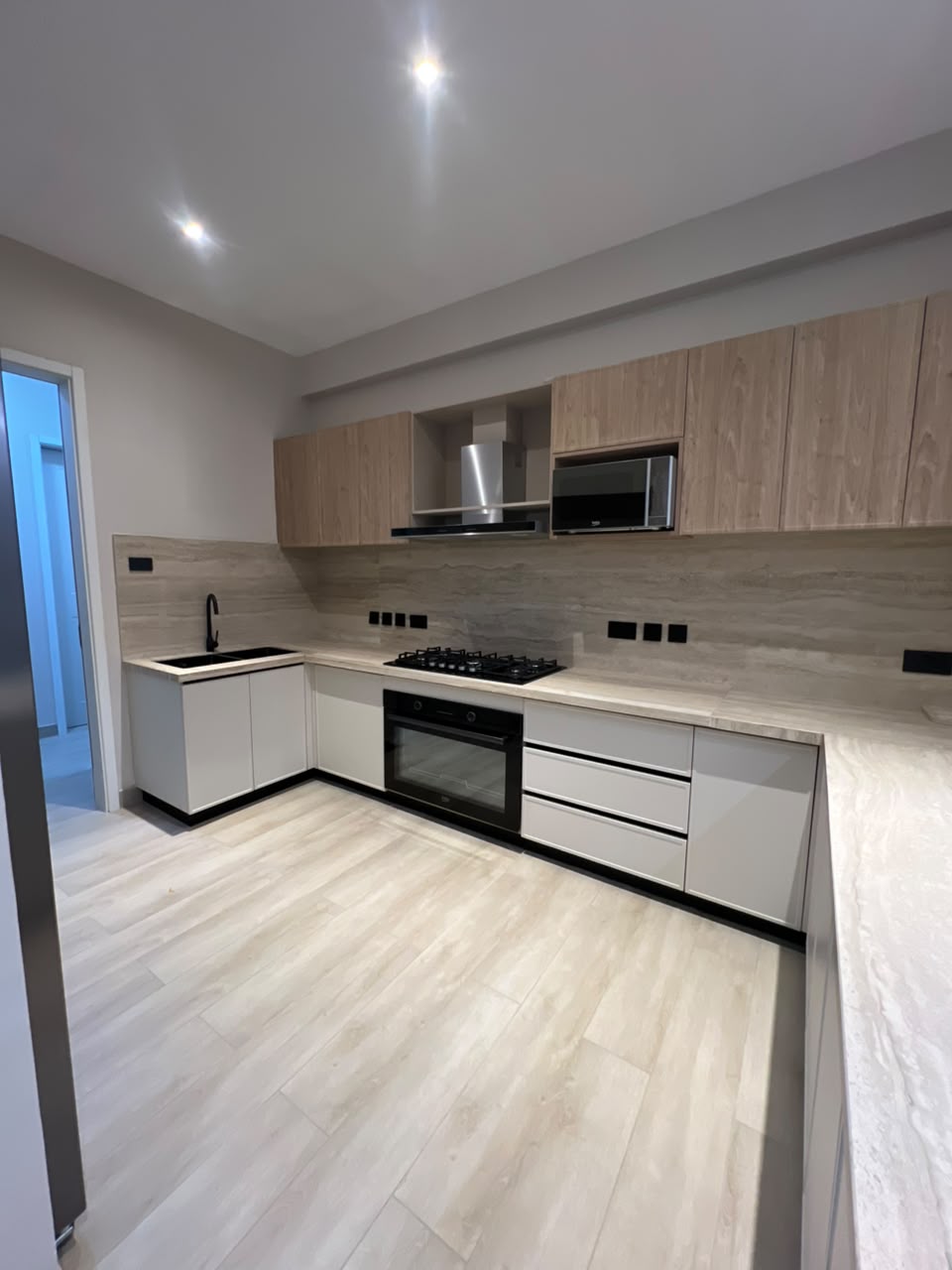 Modern fitted kitchen at Verona Apartments Westlands with an oven, hob and wooden cabinets