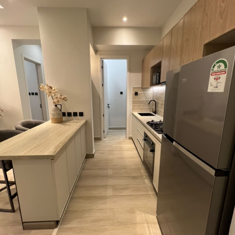 Galley-style kitchen at Verona Apartments Westlands with fitted cabinets and refrigerator
