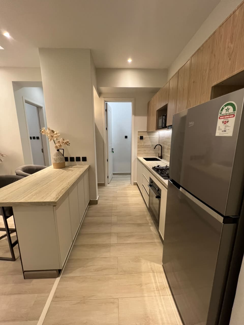 Galley-style kitchen at Verona Apartments Westlands with fitted cabinets and refrigerator