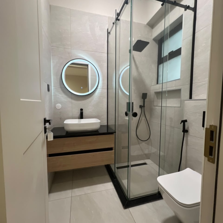 Bathroom at Verona Apartments Westlands with an enclosed glass shower and modern black fixtures