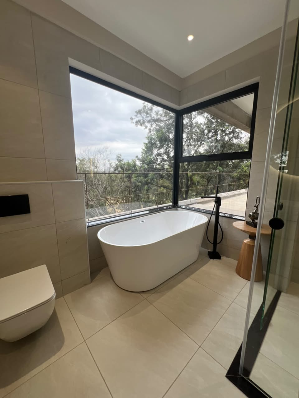 Master bathroom at Verona Apartments Westlands with a freestanding bathtub and corner windows