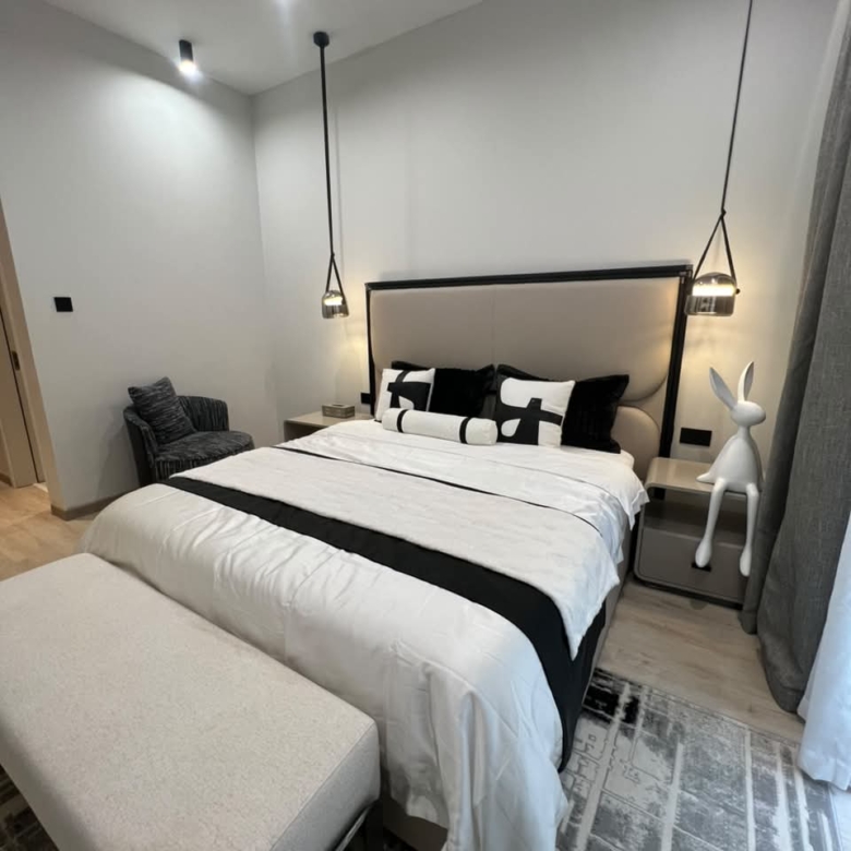 Modern bedroom at Verona Apartments Westlands with pendant lights and an upholstered headboard