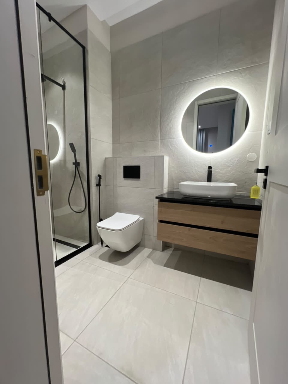 Modern ensuite bathroom at Verona Apartments Westlands with a glass shower and illuminated mirror