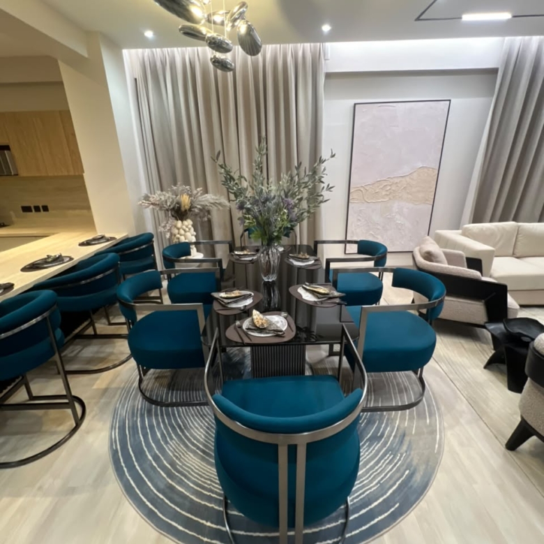 Open-plan dining area at Verona Apartments Westlands with teal chairs and modern lighting