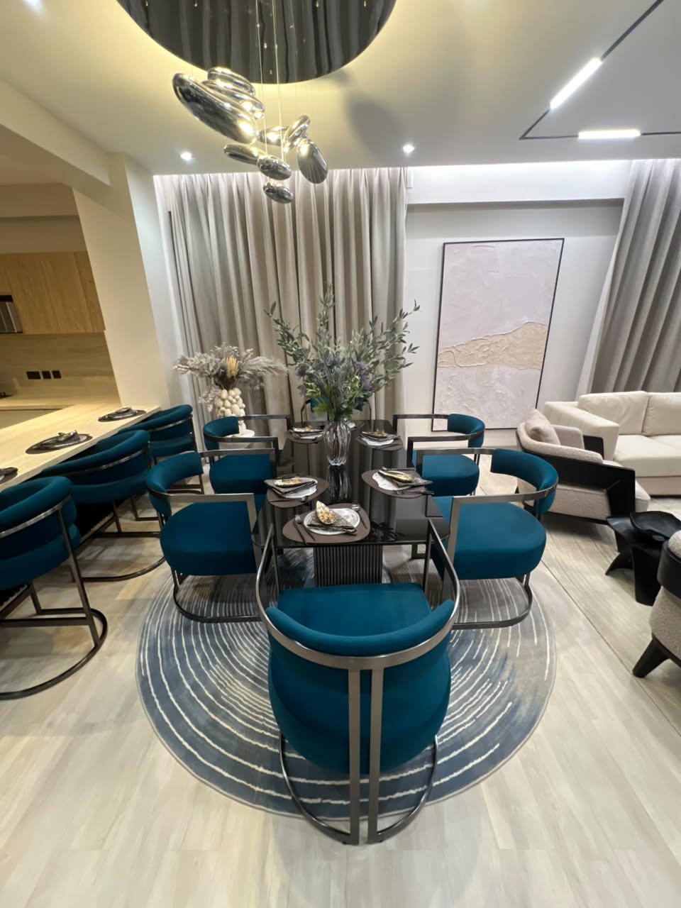 Open-plan dining area at Verona Apartments Westlands with teal chairs and modern lighting