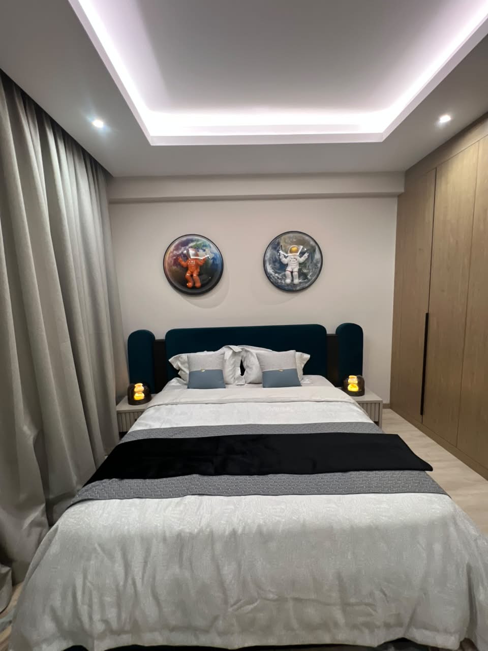 Front view of a furnished bedroom at Verona Apartments Westlands with a teal headboard