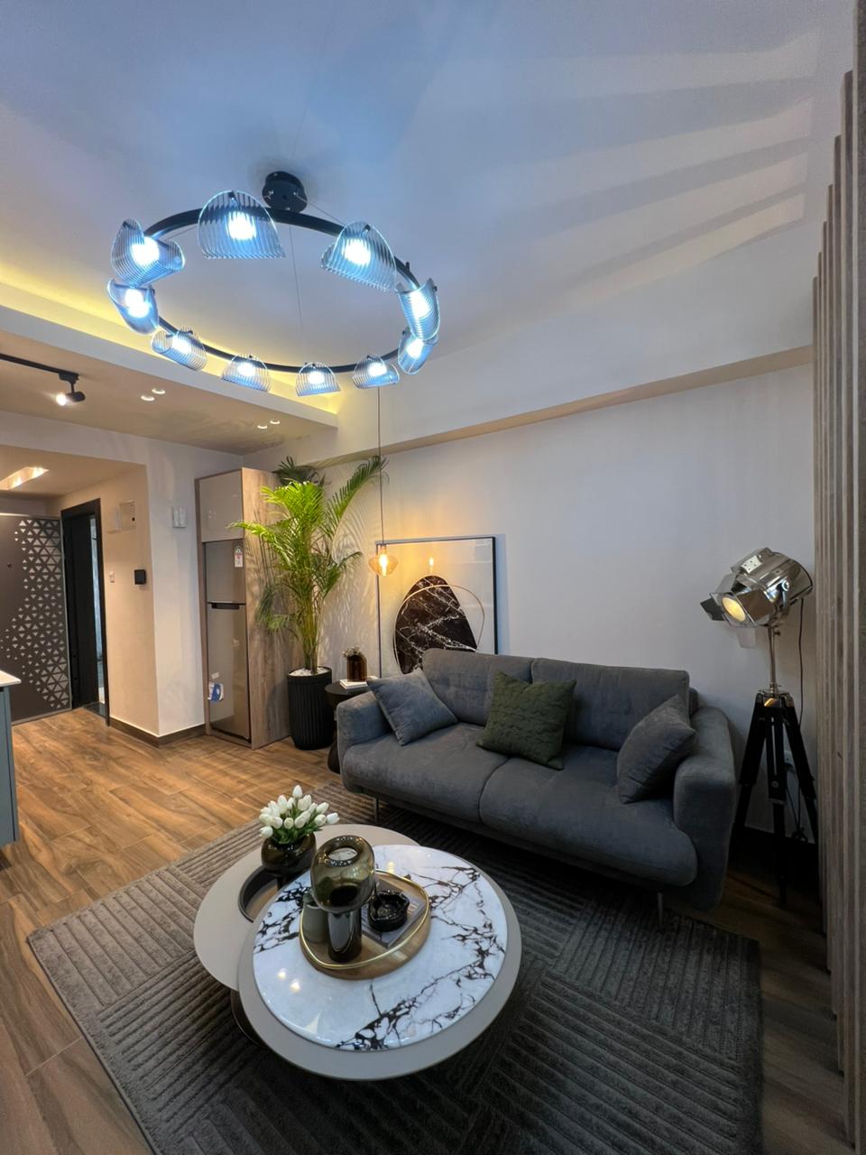Symphony Residence contemporary lounge featuring a grey sofa, marble-effect coffee table, decorative ceiling light and modern interior furnishings.