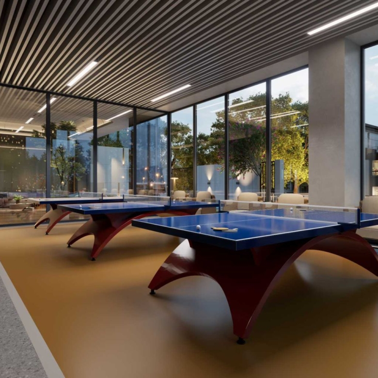 Oxford Homes Residency indoor games room featuring two table tennis tables, lounge seating, floor-to-ceiling windows, and modern ceiling lighting.