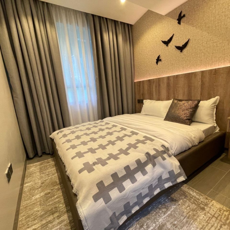 Furnished bedroom with illuminated feature wall at Padmore Residency