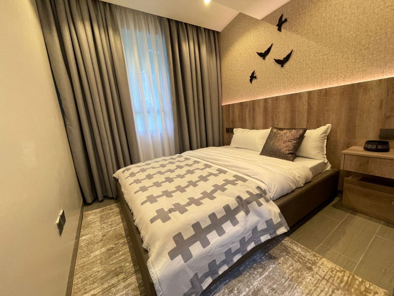 Furnished bedroom with illuminated feature wall at Padmore Residency