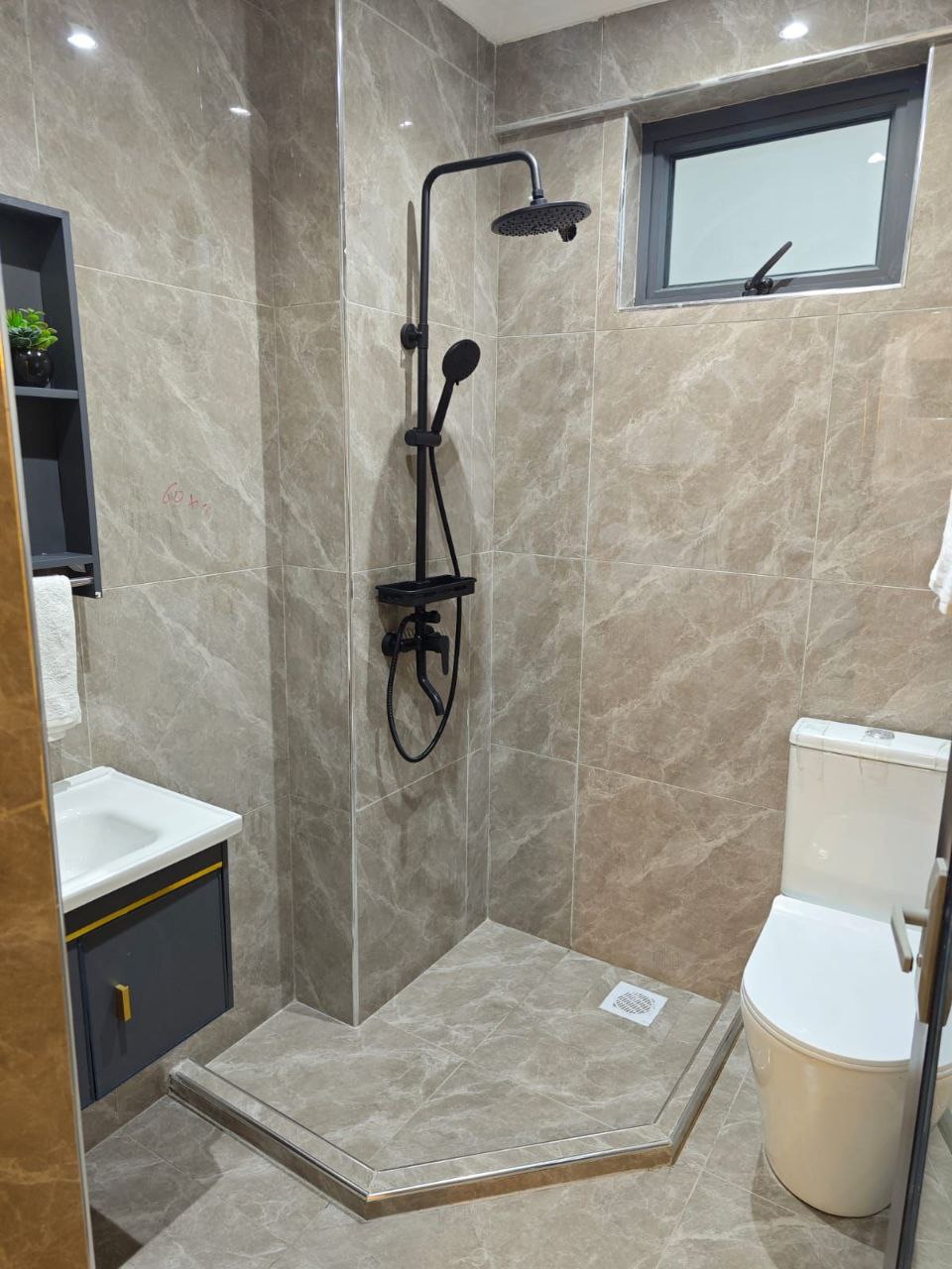 Modern tiled bathroom with rainfall shower at Padmore Residency