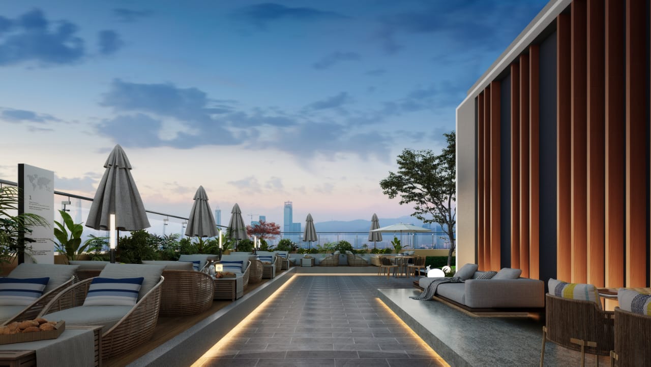 Golden Mansion Apartments rooftop lounge featuring outdoor sofas, sun loungers, parasols, landscaped plants, decorative lighting, and distant city views.