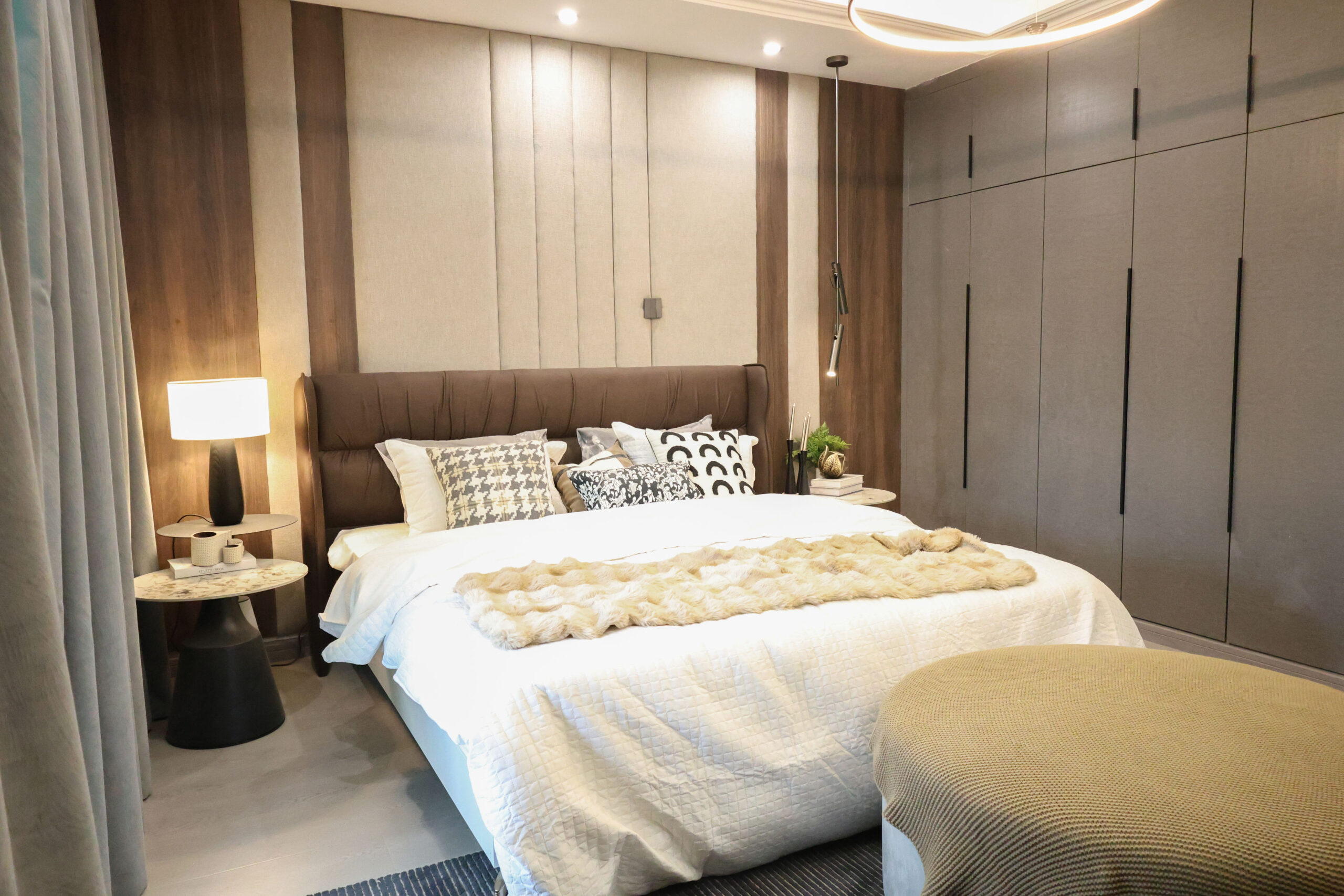 Modern bedroom with a large upholstered bed and fitted wardrobes at Venus Oak Residency in Kileleshwa.