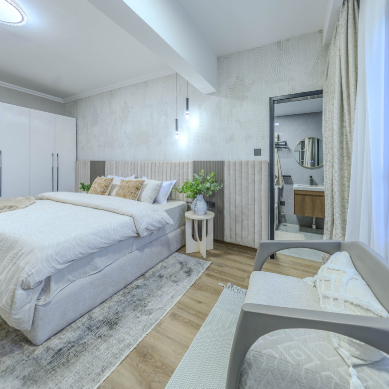 Marina Bay Phase III bedroom with fitted white wardrobes, upholstered bed, contemporary pendant lighting, and ensuite bathroom access.
