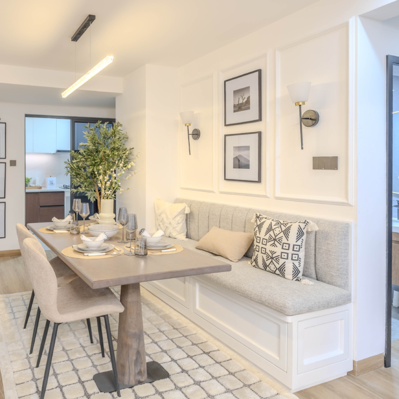 Marina Bay Phase III dining room featuring cushioned bench seating, modern dining chairs, pendant lighting, and wooden flooring.