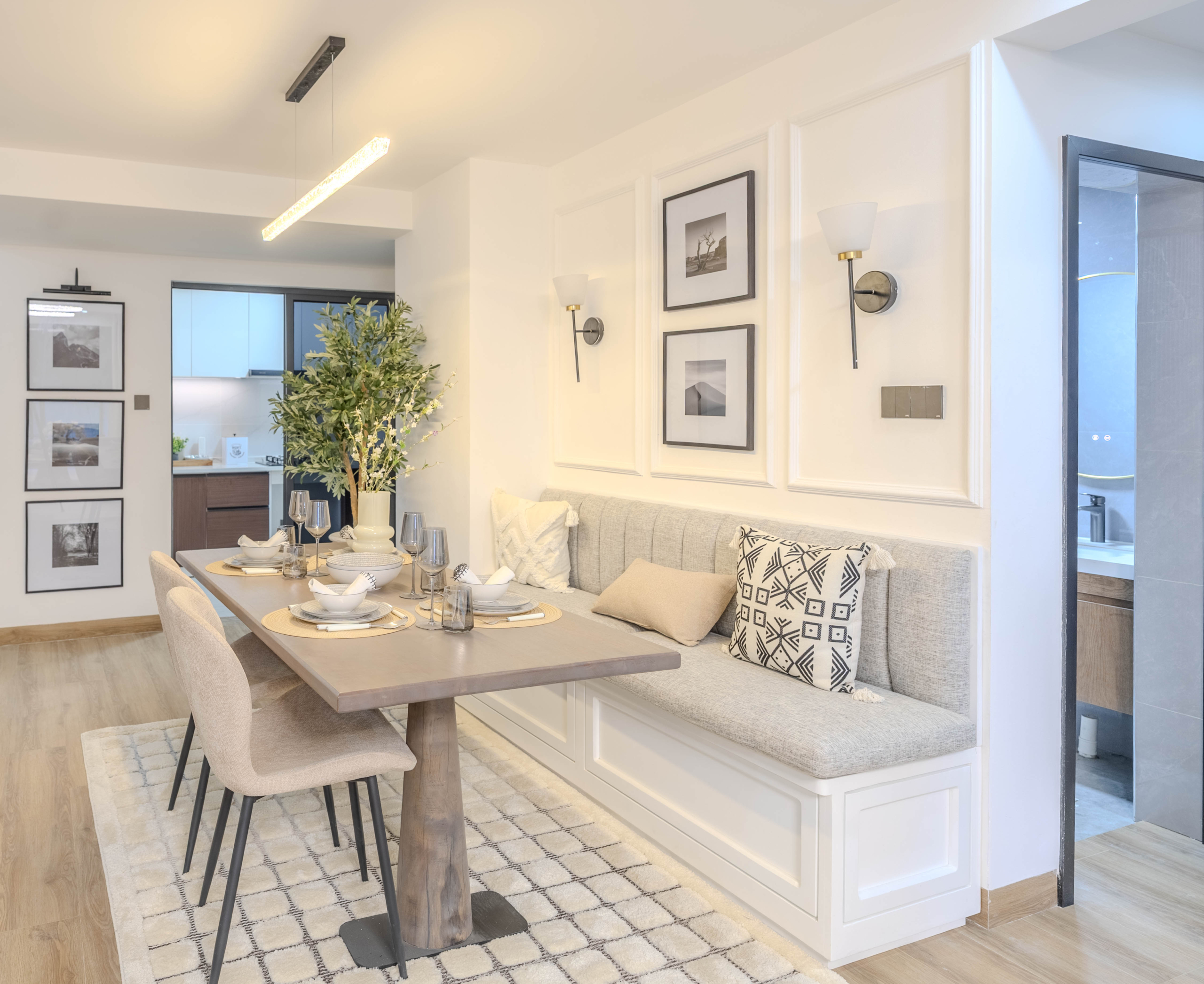 Marina Bay Phase III dining room featuring cushioned bench seating, modern dining chairs, pendant lighting, and wooden flooring.