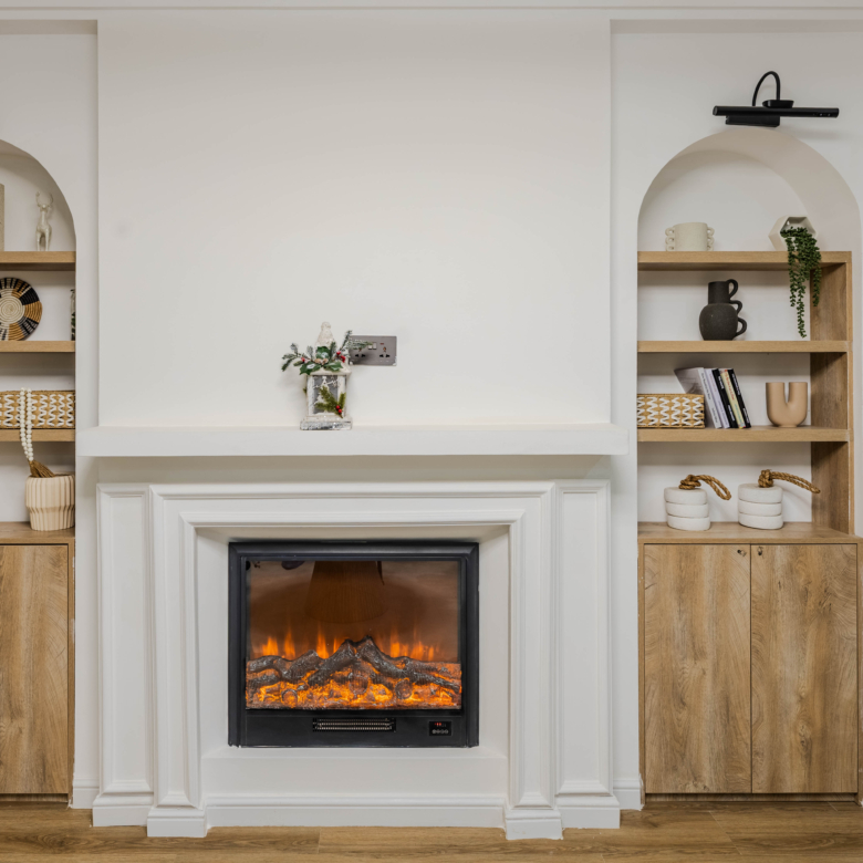 Marina Bay Phase III interior fireplace with white decorative surround, wooden built-in shelving, and modern display cabinets.