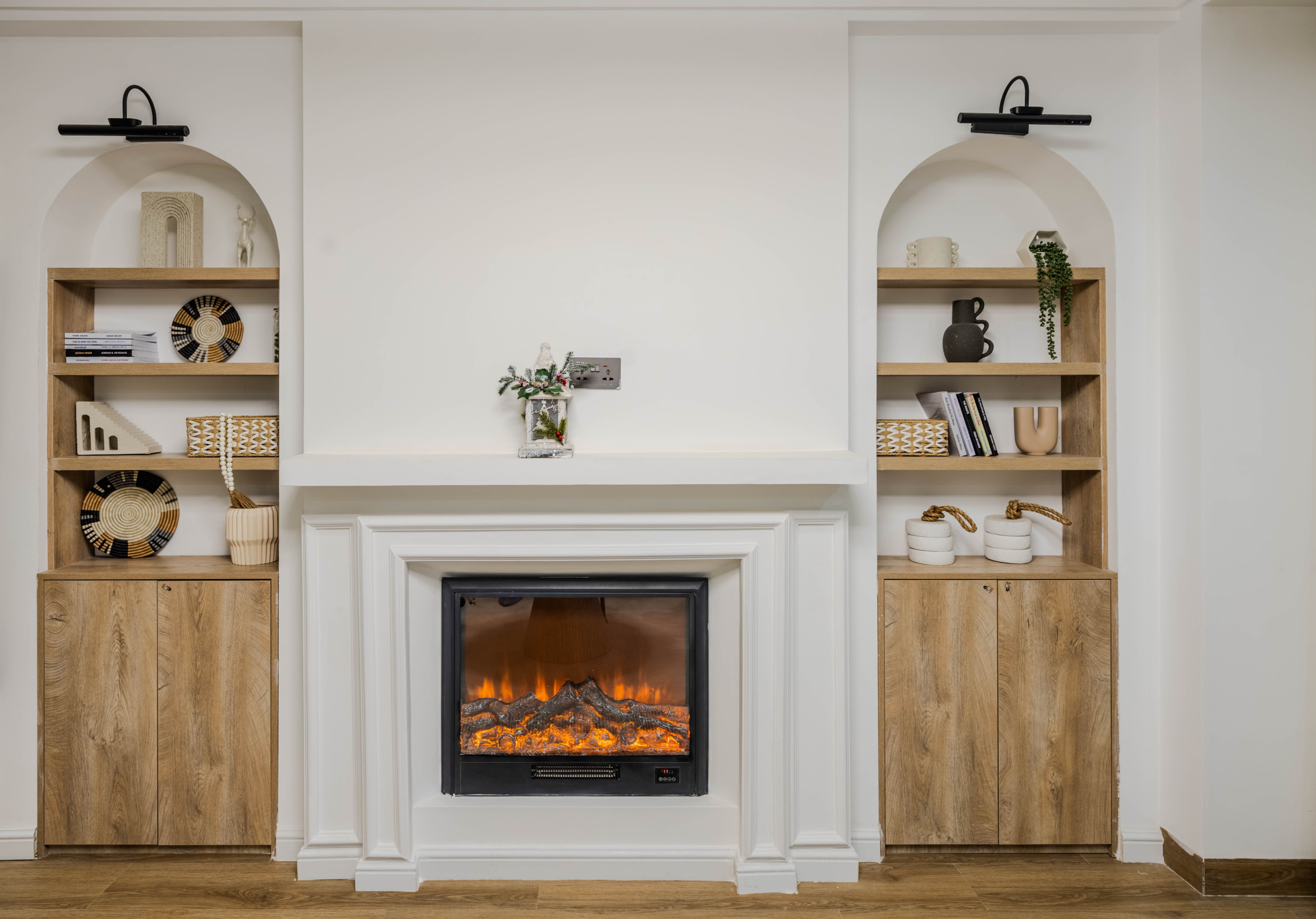 Marina Bay Phase III interior fireplace with white decorative surround, wooden built-in shelving, and modern display cabinets.
