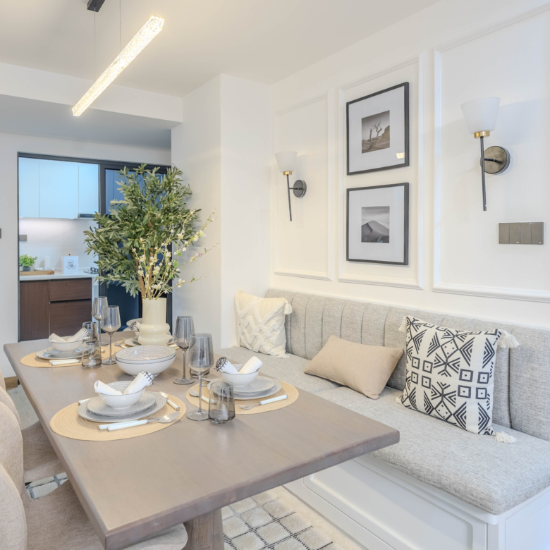 Marina Bay Phase III dining area with upholstered bench seating, wooden dining table, modern lighting, and decorative wall panels.