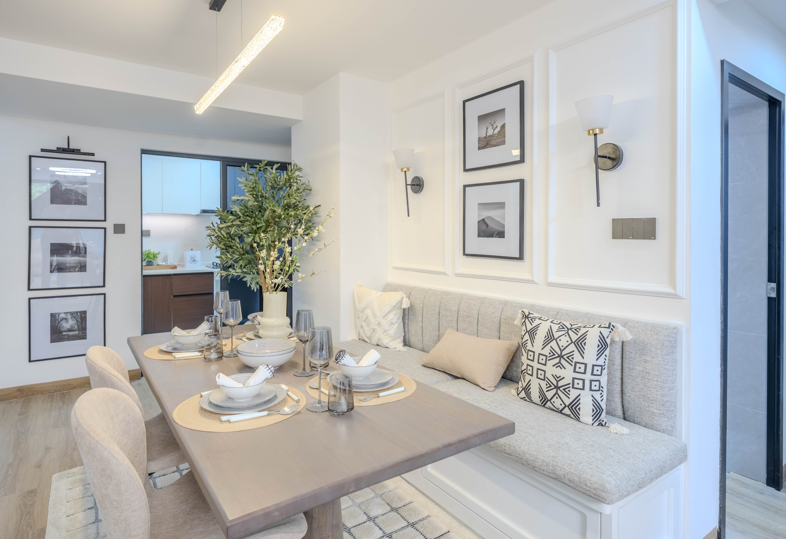 Marina Bay Phase III dining area with upholstered bench seating, wooden dining table, modern lighting, and decorative wall panels.