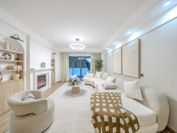 Marina Bay Phase III spacious living room featuring a cream sectional sofa, decorative fireplace, modern ceiling lights, and balcony access.