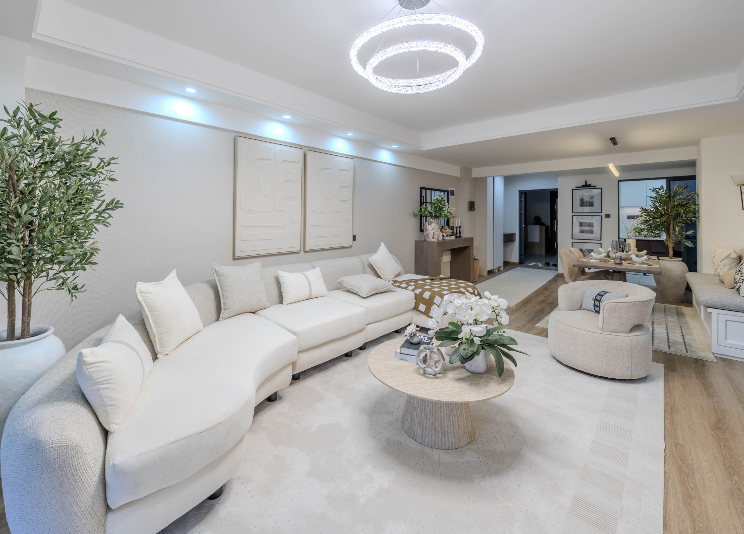 Marina Bay Phase III open-plan living room with large sectional sofa, modern coffee table, pendant lighting, and adjoining dining area.