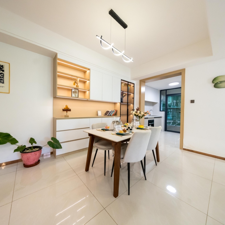 Rhapta One Residency modern dining area with wooden dining table, upholstered chairs, illuminated display shelves, and contemporary pendant lighting.