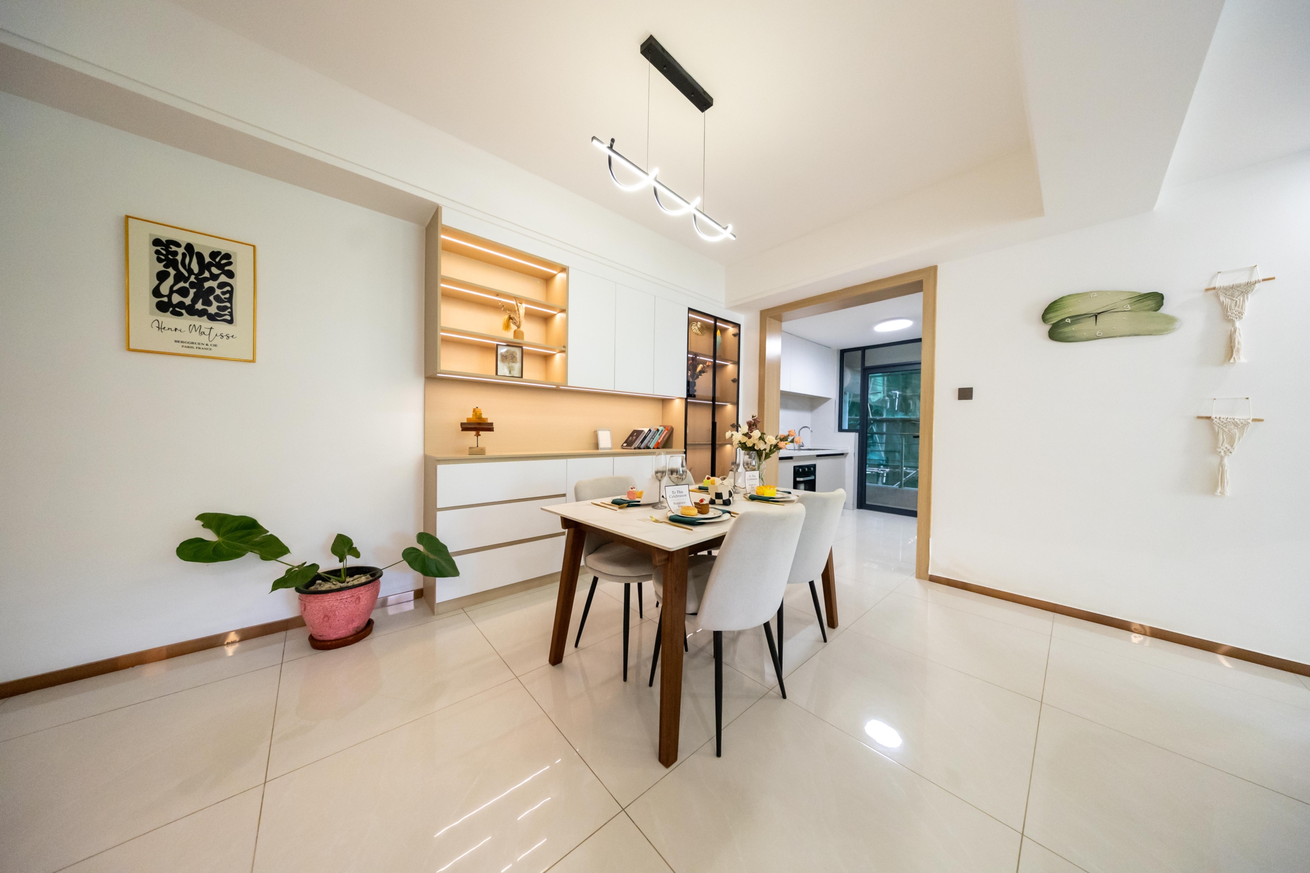 Rhapta One Residency modern dining area with wooden dining table, upholstered chairs, illuminated display shelves, and contemporary pendant lighting.