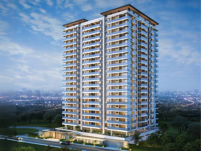 Ilu Green Homes exterior architectural rendering showing a modern high-rise residential development with two connected tower sections, multiple balconies, contemporary façades, and landscaped surroundings.