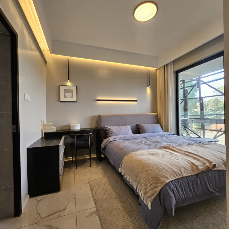 Spacious bedroom with study desk and private balcony at ILU Green Homes