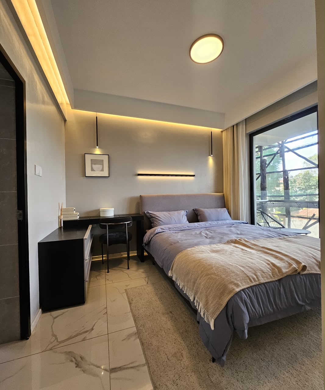 Spacious bedroom with study desk and private balcony at ILU Green Homes