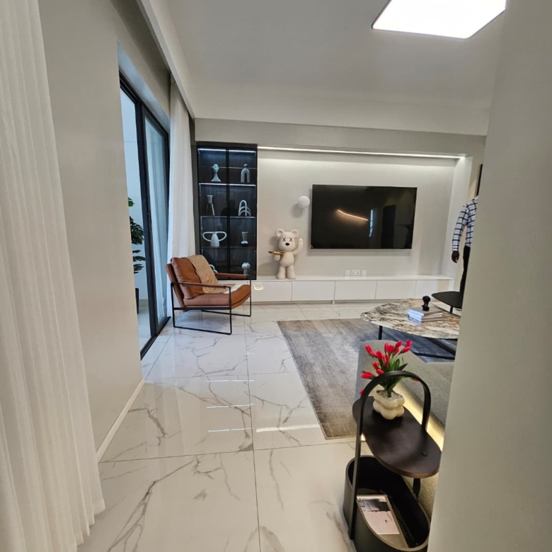 Entrance view of a modern living room with TV wall at ILU Green Homes Kilimani