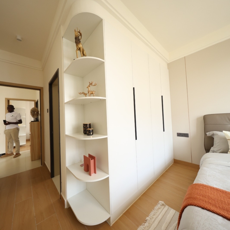 Bedroom with fitted wardrobes and display shelving at Luster Arbor Residency