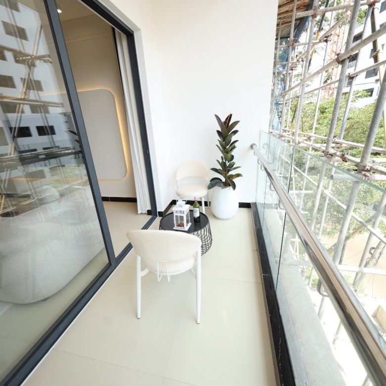 Private apartment balcony with seating and glass railing at Luster Arbor Residency