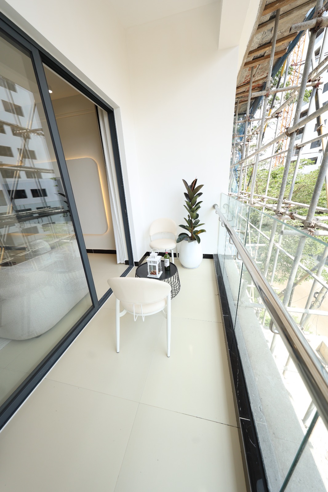 Private apartment balcony with seating and glass railing at Luster Arbor Residency