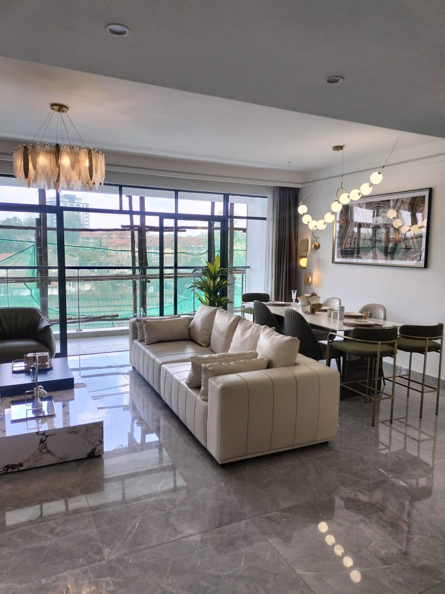 Riara One Residency furnished living and dining room featuring cream sofa, modern dining table, chandelier, marble-look flooring, and balcony.