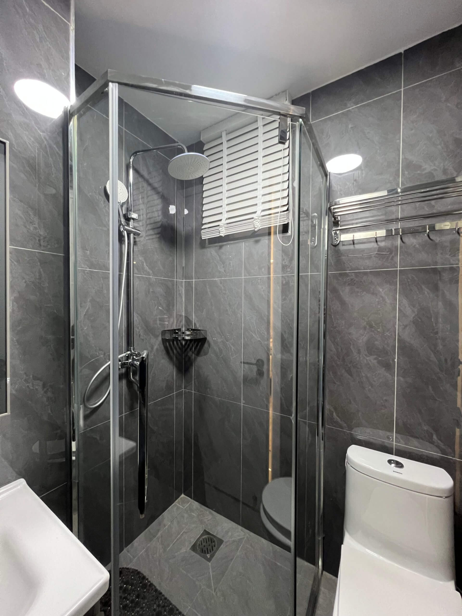 Modern bathroom vanity and shower cubicle at Ten50 Residences.