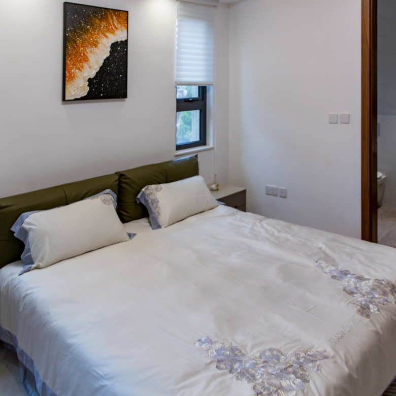 Furnished bedroom with ensuite bathroom at Sunset Park Apartments