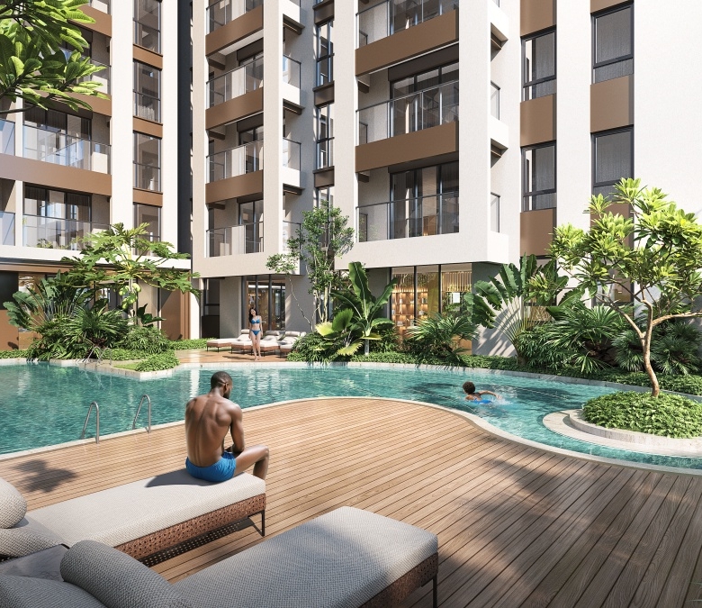 Lesonia Residence outdoor swimming pool with landscaped gardens, wooden pool deck, sun loungers, and surrounding apartment balconies.