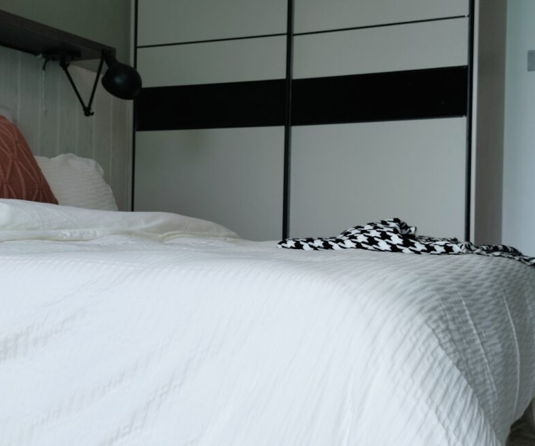 Citi Rise Residency in Westlands bedroom with modern bed, fitted wardrobe and black wall lamp