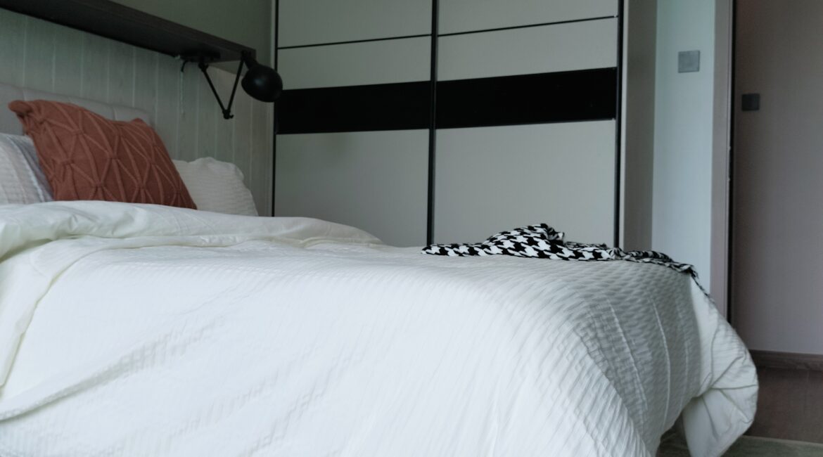 Citi Rise Residency in Westlands bedroom with modern bed, fitted wardrobe and black wall lamp