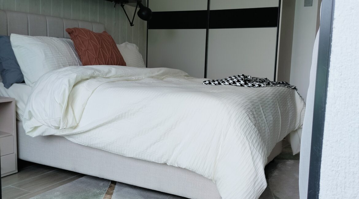Citi Rise Residency in Westlands bedroom with upholstered headboard, floating shelf and twin wall lamps